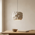 A pendant light with a sculptural, bulbous design that mimics the natural formations of clouds, with a matte white finish that adds softness and tranquility to the interior space.