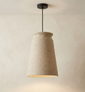 A pendant light unit with a design that mimics traditional pottery with a modern touch, wrapped in a rough natural fabric (such as linen or burlap) to distribute warm and soft light that adds tranquility and authenticity to the architectural space.